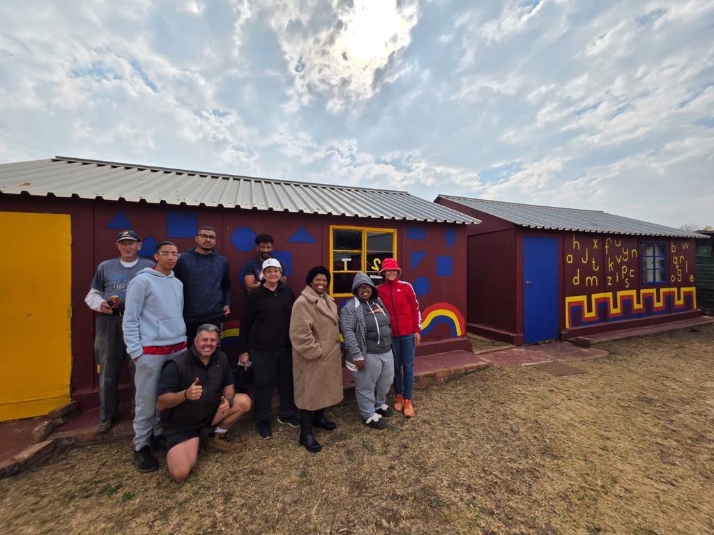 Volunteers outside freshly painted early childhood development classrooms