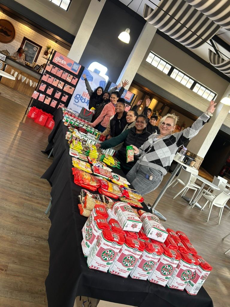 Volunteers behind tables of collected food donations