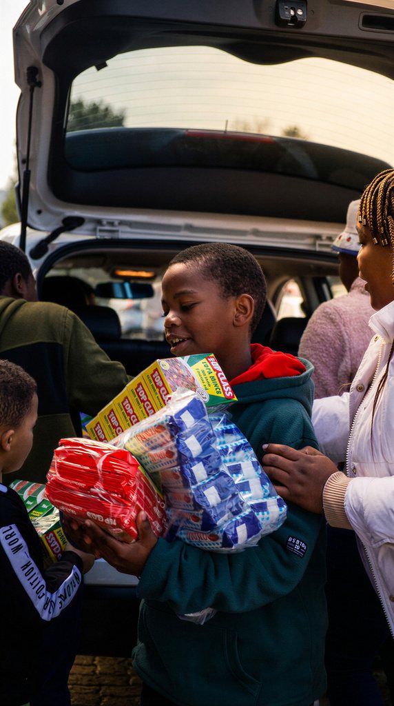 A young boy carrying groceries received through the Mercy Fund