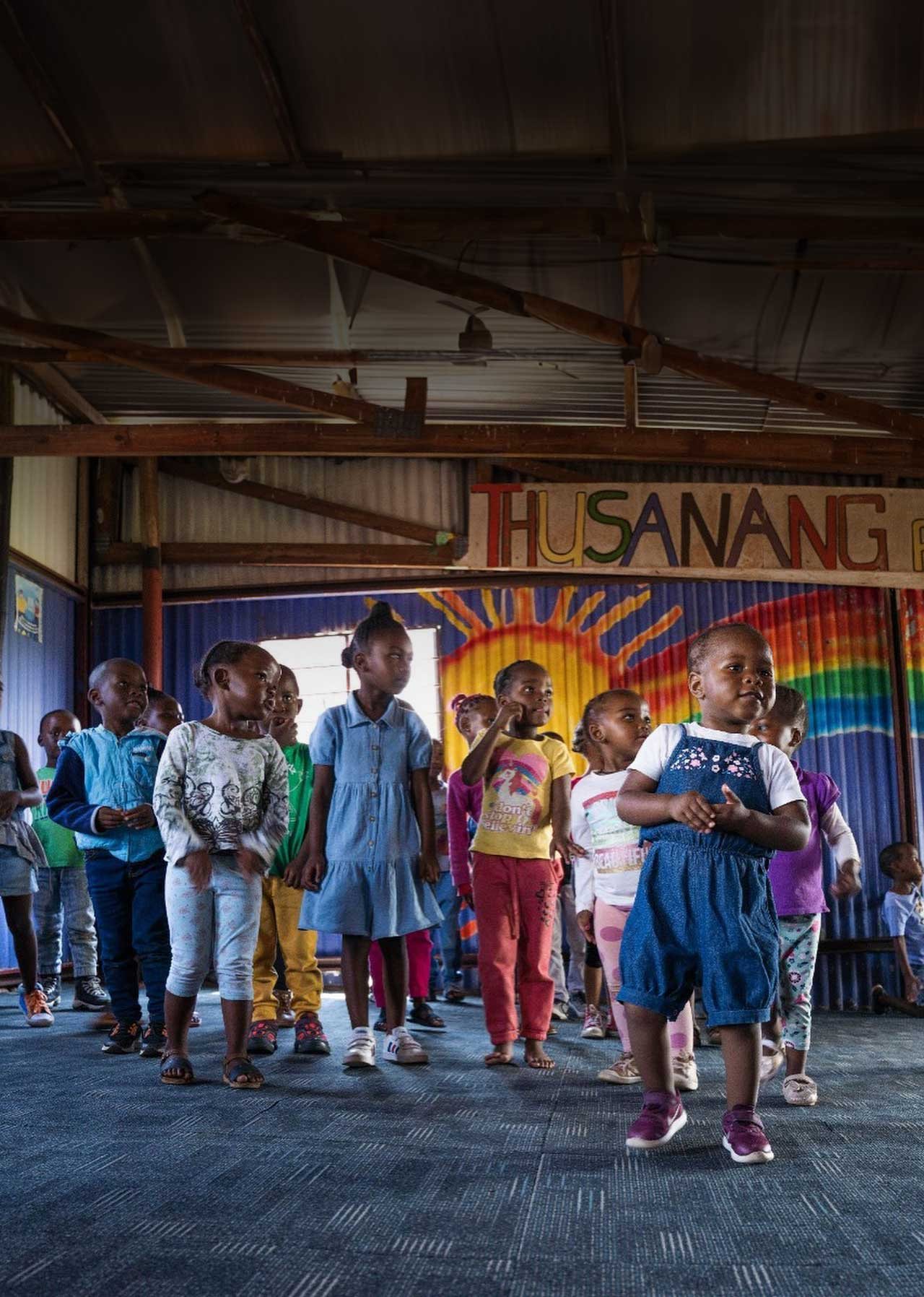 Children outside a brightly painted pre-school classroom